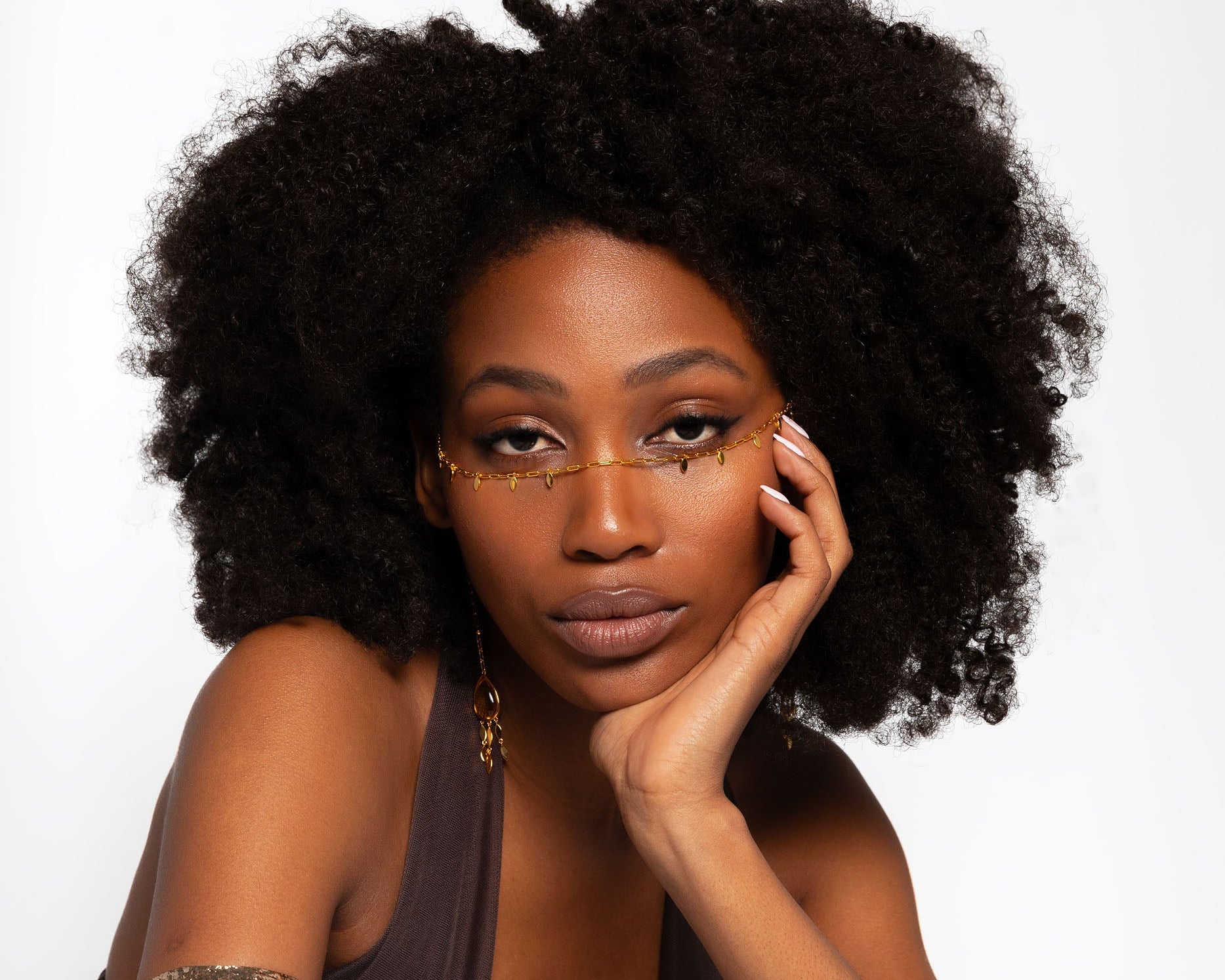 Woman with an afro hairstyle posing against a white background